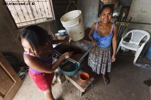 Guatemala, Izabal, Agua Caliente. Broyage et pétrissage du maïs, préparation pour galette