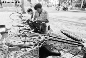 Vietnam, Hanoï. Réparation d'une crevaison de pneu de vélo. Août 1995 © Willy Blanchard